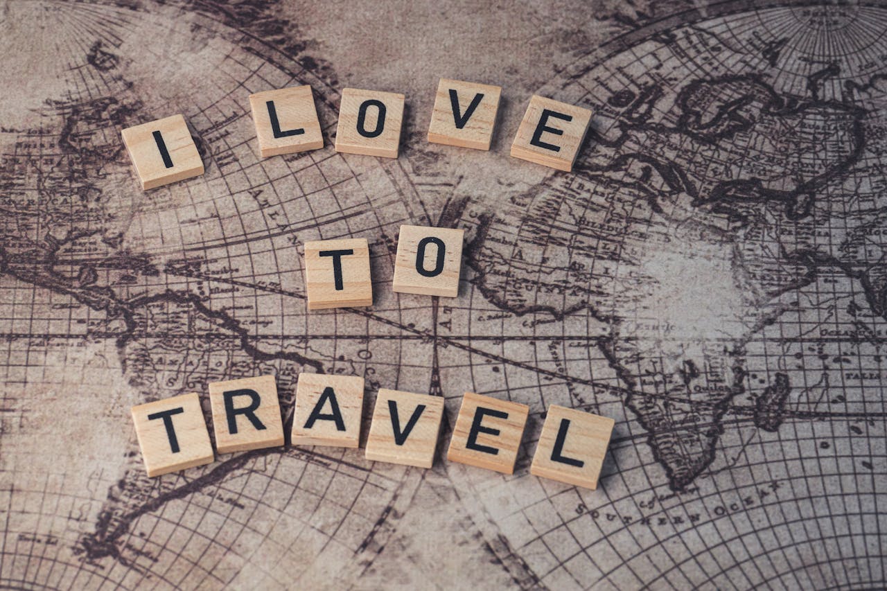why-choose-us Wood scrabble tiles spelling 'I Love to Travel' on a vintage map.