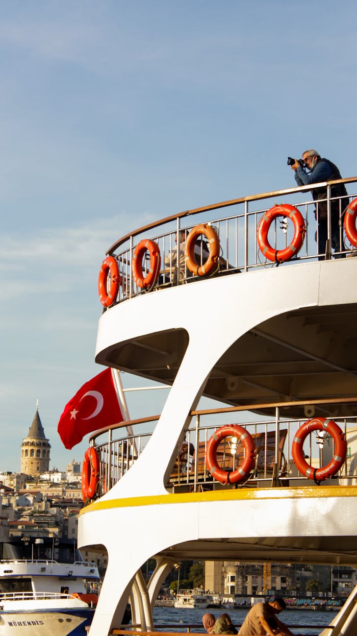 A scenic view of a photographer on a ferry with the Galata Tower in the background, Istanbul.
