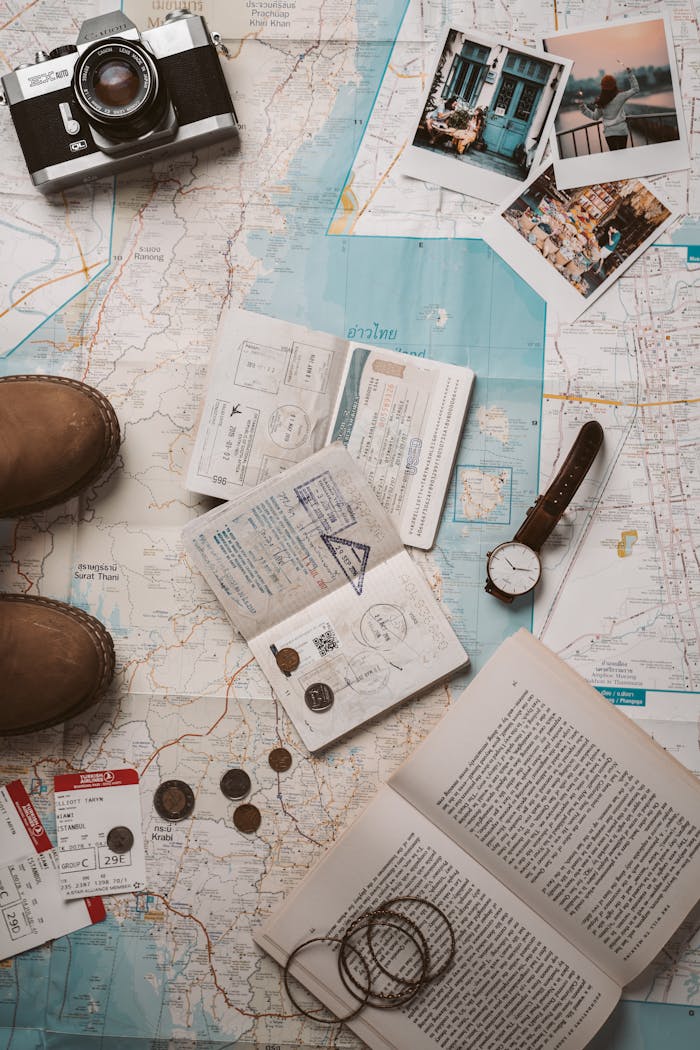 gallery-2 Flat lay of travel essentials featuring a map, camera, and passport stamps, perfect for wanderlust inspiration.